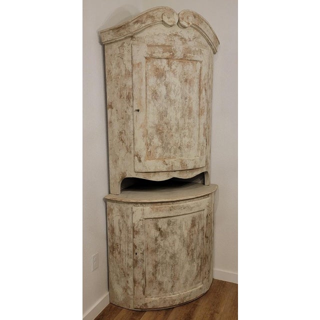 Beautiful Swedish Corner Cabinet in the Gustavian Style with a scrolled or gooseneck decorative architectural feature at...