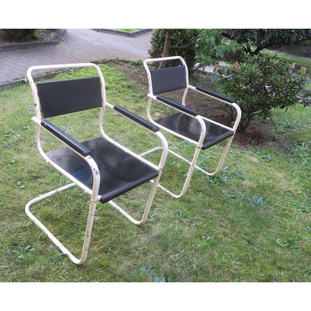Mid century pair of painted iron and wood garden or patio chairs.