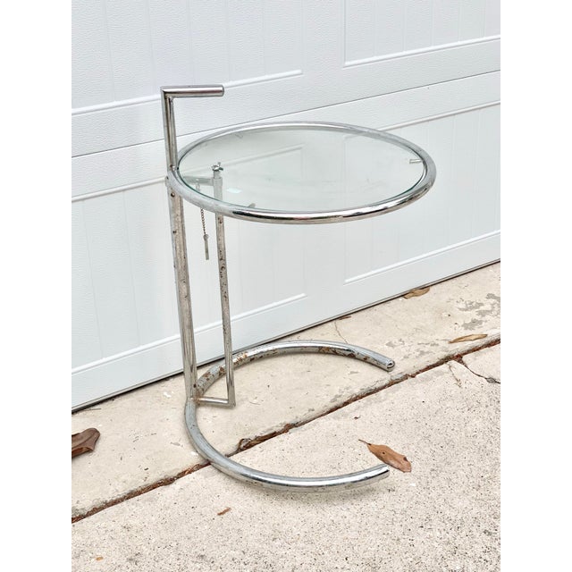 Vintage adjustable chrome and glass side table. Contemporary design. Height can be adjusted. Glass table top height is...