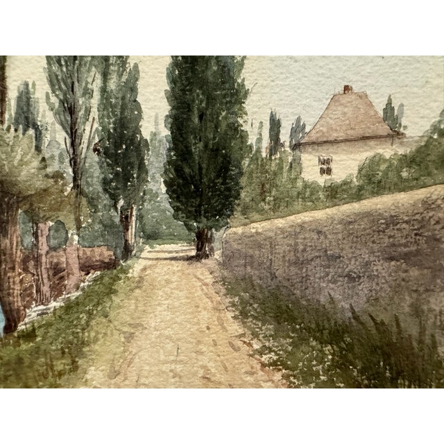Original watercolor on textured paper depicting a tranquil waterside road lined with tall poplar-like trees and pollarded...