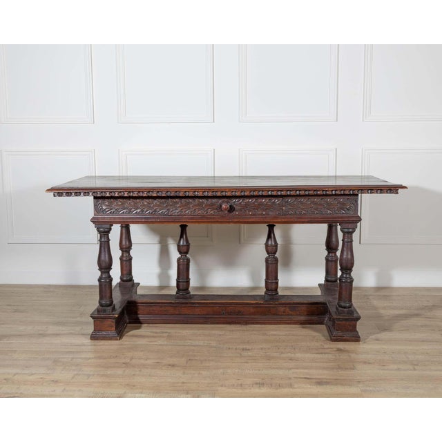 An exceptional Lombard Louis XIV table from the first half of the 17th century, masterfully carved in solid walnut. This...