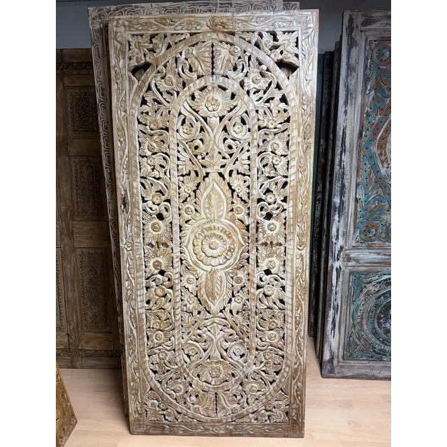 An exquisite vintage door showcasing intricate hand-carved floral lattice work, left in its natural wood finish to...