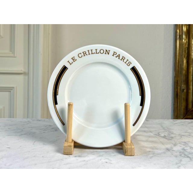 A rare vintage porcelain plate made for the legendary Hôtel de Crillon in Paris, featuring the distinctive black-and-gold...
