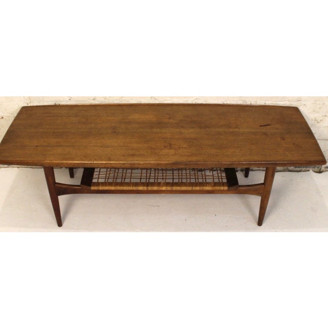 This Danish coffee table is made of teak and wicker. The piece features a two tiered design providing ample space. The...