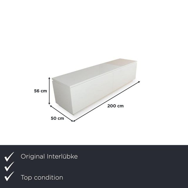 This lowboard is a long, elegant piece of furniture with a clean, minimalist design. The continuous, glossy front doors...