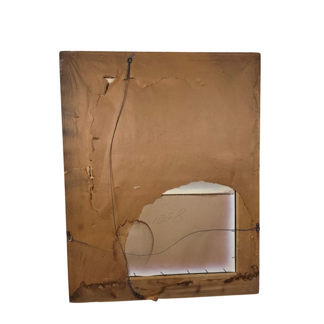 A striking vintage Hollywood Regency wall mirror, circa 1970s, featuring a dramatic black-and-gold rectangular frame with...