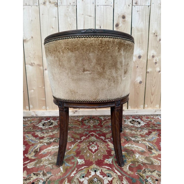 A louis xvi style office chair in a dark walnut-stained carved wood, with tapered and fluted legs topped with carved...