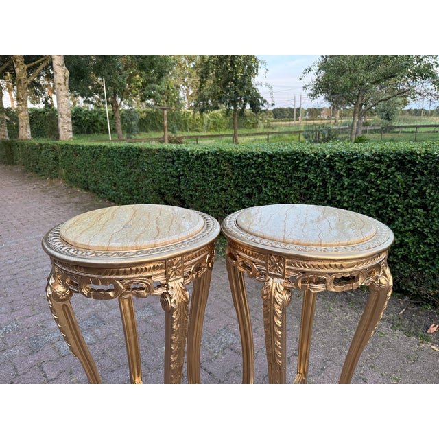 This elegant pair of 1970s French Louis XVI–style side tables combines finely carved solid beechwood frames with original...