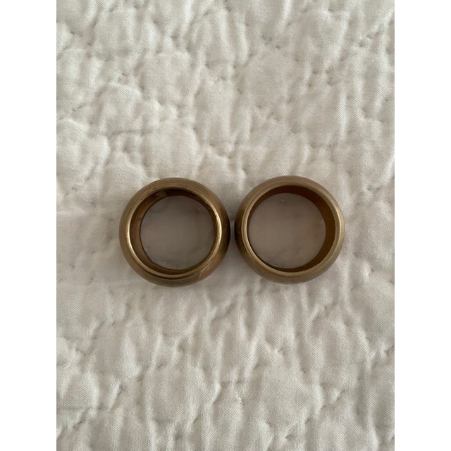 Set of 2 vintage brass napkin rings. Features rounded brass center bordered by solid brass band on each side - top and...