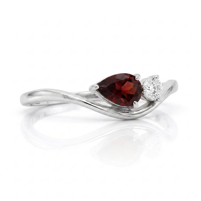 Infuse your style with timeless romance through this gently curved band, beautifully aligning a deep crimson teardrop...