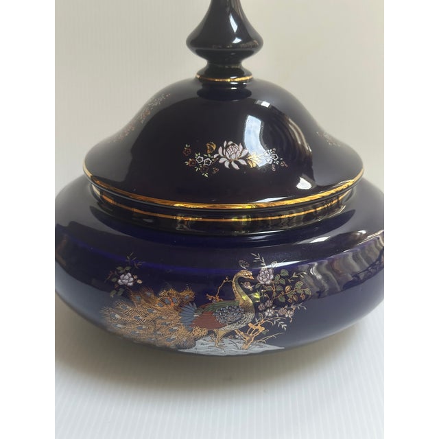 Decorative ceramic porcelain cobalt blue round vase jar dates back to mid-20th century with hand painted colorful peacock...