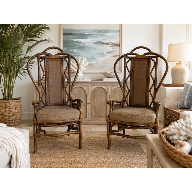 Beautiful vintage pair of high back arm chairs featuring bent rattan frames, woven wicker panels, decorative wrapped...