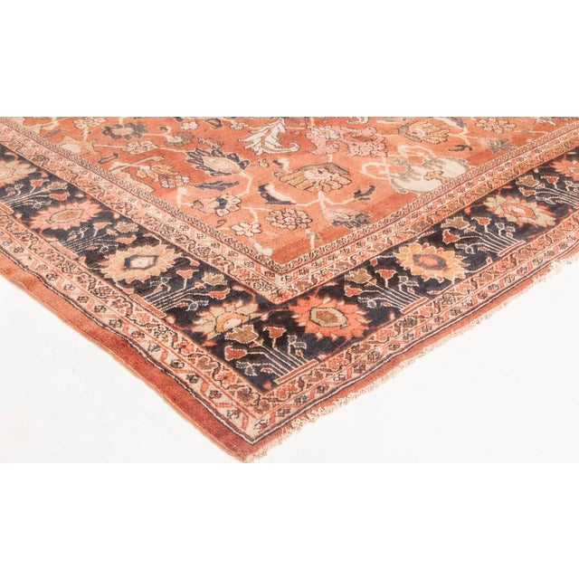 An early 20th century Persian Antique sultanabad rug, the cinnamon field with a palmette, vine and enlarged leaf trellis...