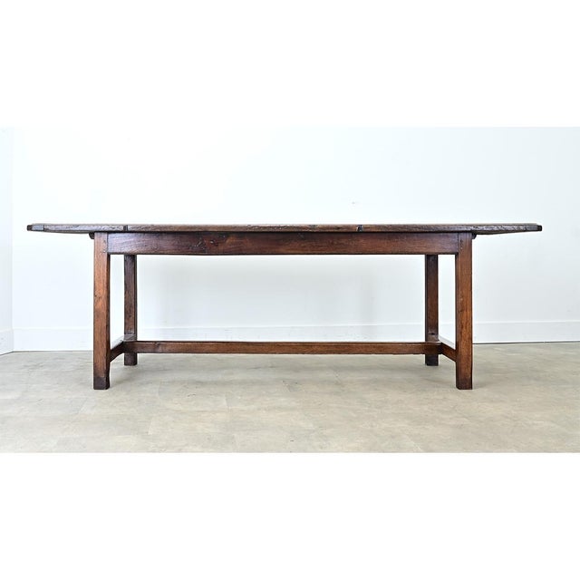 A 19th-century French farm table made from solid oak. The top consists of 2 wide oak planks, whose rich patina combines...