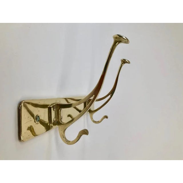 A useful, simple, elegant coat rack from Jugendstil period produced in Austria. Composed of two solid brass coat hooks...
