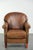 This vintage sheepskin armchair features a beautiful patina and is finished with decorative nails. The armchair has a...