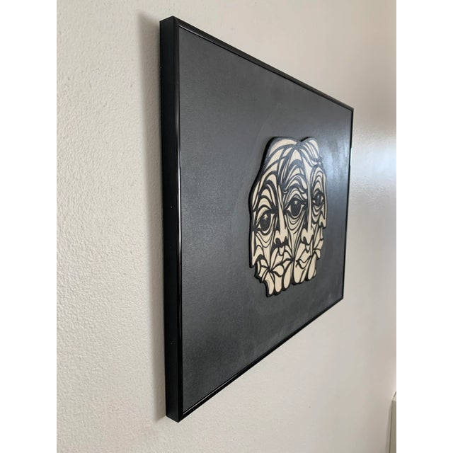 Jere Carrasco - "Quatro" A framed drawing of a four faced head with bold black lines on a white ground. The pieces is set...