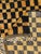 This striking Moroccan M’rirt rug features a bold checkerboard pattern in deep black and warm ochre, offering a modern...