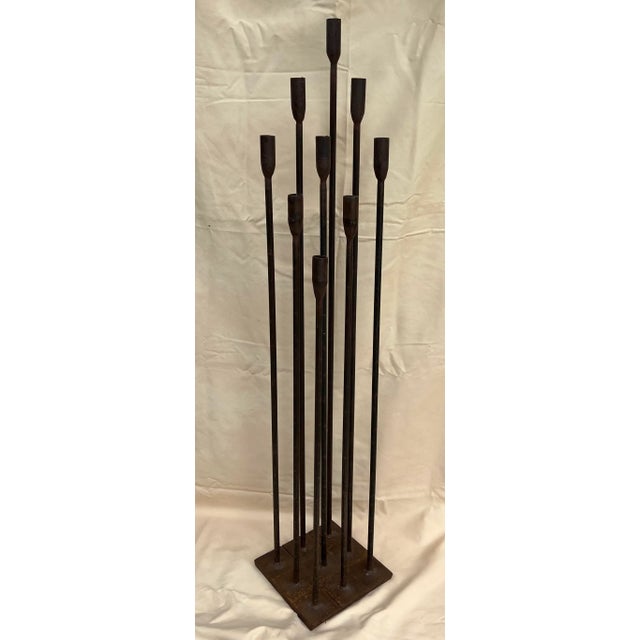 This is made of heavy iron. Hard to tip over. Very cool ! Made extremely well. Has the trumpet style candle holders.