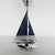 An deco table lamp. Chromed metal stem in the shape of a sailboat with a chromed riveted base and a white glass globe...