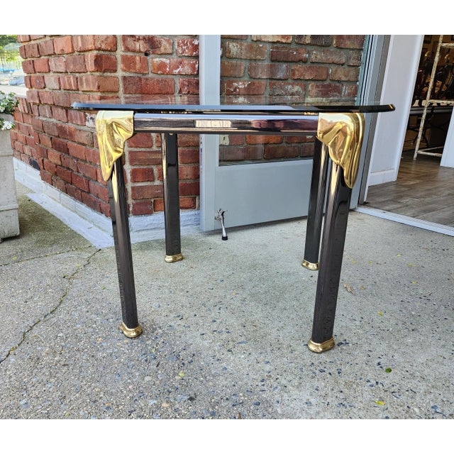 High Quality Vintage gun metal and brass base side table with a beveled glass top. This table combines a mix of metals and...