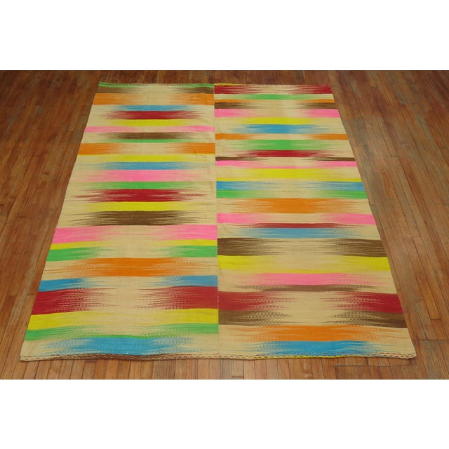 A one of a kind one-off Turkish Kilim featuring a rainbow color palette.