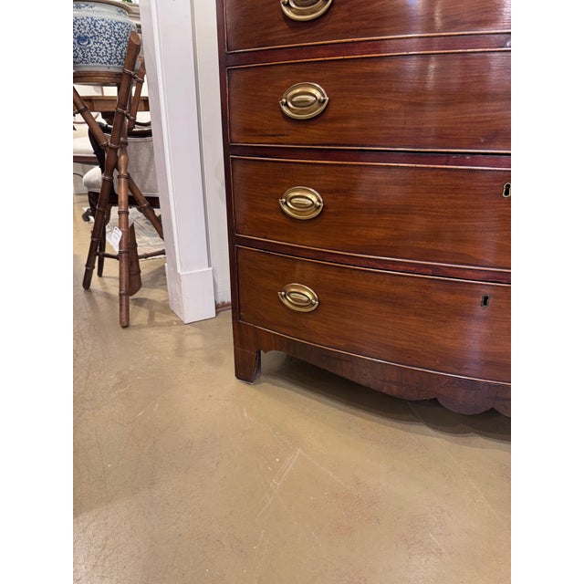This 19th century English Bow Front Chest of Drawers is a beautifully designed piece of furniture, featuring tastefully...