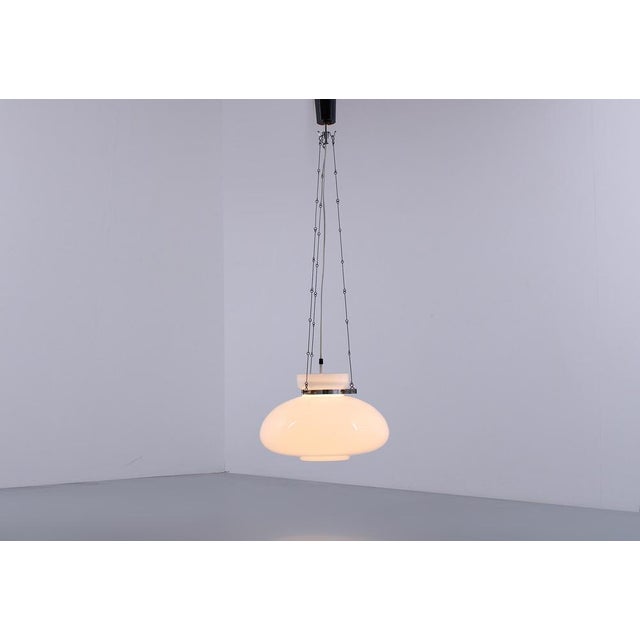 Fantastic white opaline glass pendant lamp by Glashutte. The lamp shade is hanging by a delicate iron chain suspension....