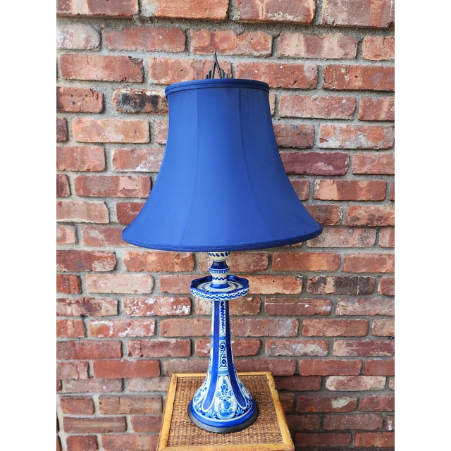 An unusual late nineteenth century Delft candlestick lamp decorated with tulip baskets and stylized S scroll motif with...