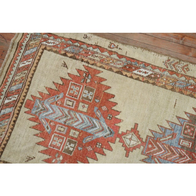An early 20th century Persian Serab rug with a large scale tribal design on a soft camel colored ground. Accents in brown,...