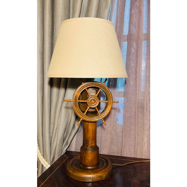 A wonderfully character-rich nautical table lamp crafted in warm-toned wood with an integrated ship’s wheel functioning as...