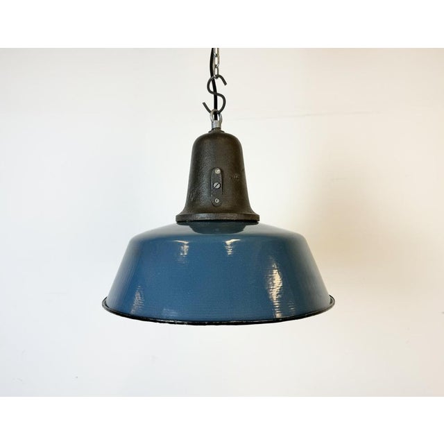 Industrial blue enamel pendant light made in Poland during the 1960s. White enamel inside the shade. Cast iron top. The...