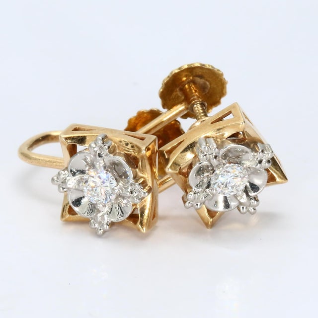 Here is a pair of 14k yellow and white gold stud earrings. Each earring features a round white diamond at the center,...