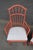 Pair of Windsor-style armchairs featuring a red-painted finish, arched crest rails, turned spindle backs, and spindle-...