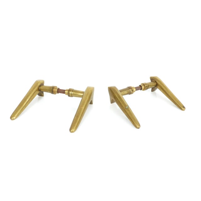 A set of two pairs of modernist door handles in solid brass. Their aerodynamic silhouette recalls the influences of...