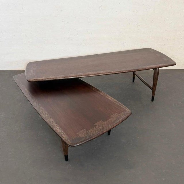 This Mid-Century Modern, ebonized walnut, "Switchblade" coffee table was designed by Andre Bus for Lane Furniture. This...