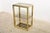This rectangular vitrine has three smoked glass tops which are supported by a brass frame with chrome accents.