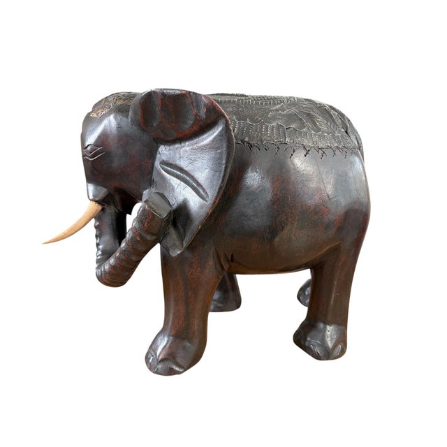 Carved from a single block of wood and embellished with brass detailing, this Asante elephant sculpture represents the...