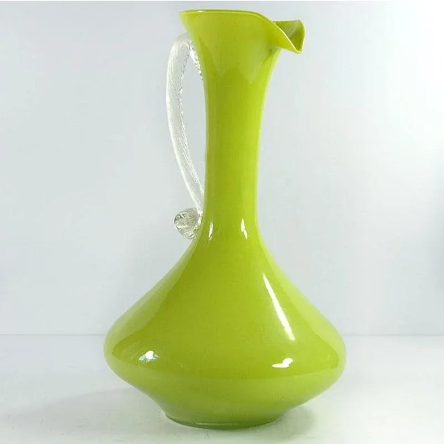 A beautiful, tall vase of hand-formed lime-colored glass. The clear handle is made of drawn glass. This is an original...
