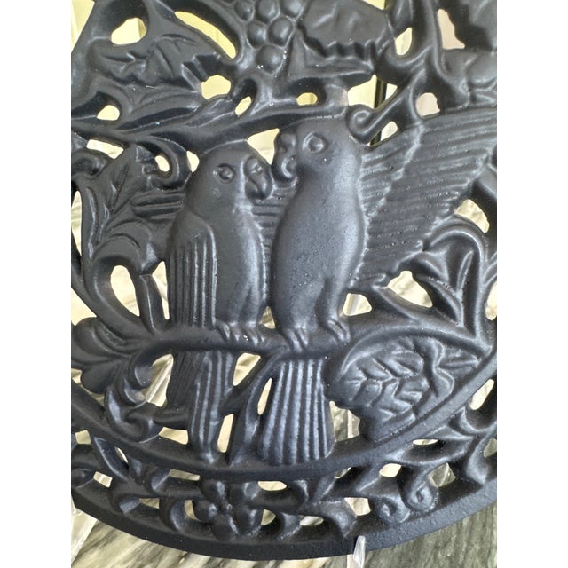 Here is a unique black cast iron trivet depicting a pair of parrots or lovebirds in a grapevine. The strength of the iron...