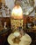 A breathtaking vintage table lamp featuring a luminous art glass shade in warm amber, cream, and honey tones, beautifully...