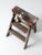 This is a vintage wooden step ladder. The rustic ladder features two rung steps with a wooden board back brace and metal...