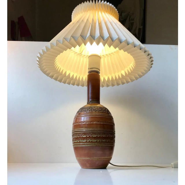 A tall gourd shaped ceramic table lamp with relief/ribbings and apllied caramel and olive green glaze. It was designed by...