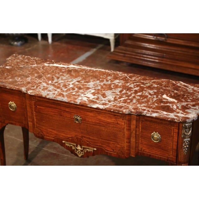 Elegant in both proportion and detail, this antique Louis XVI console combines refined marquetry, finely cast gilt-bronze...