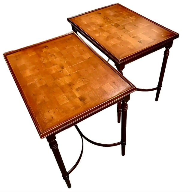 A pair of elegant English side tables with a parquet style yew wood top with beveled edge. Reeded, slim legs connected...