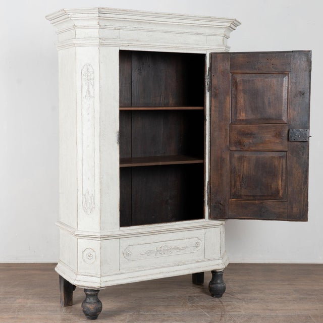 Early 19th century Swedish single door armoire crafted in oak. The cabinet features carved panels and canted sides...