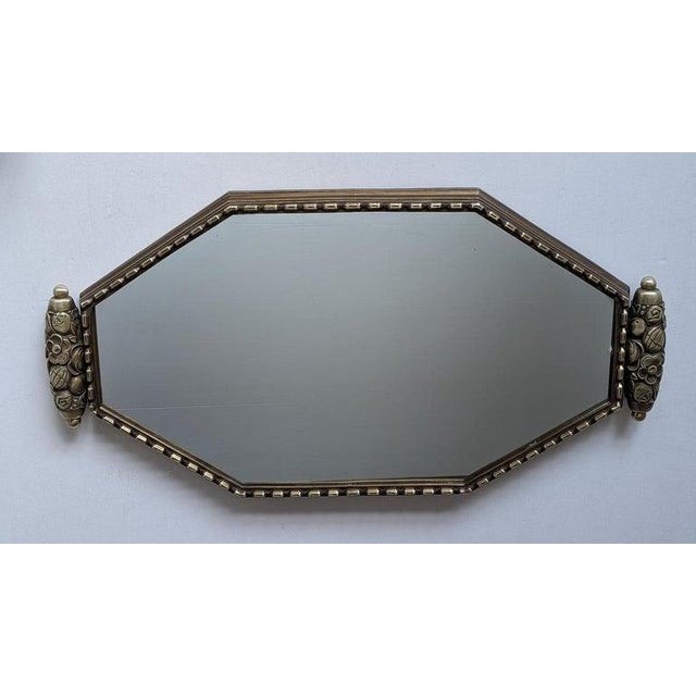 French Art Deco wall mirror with geometric and floral details. The frame is with it's old patina. A beveled mirror will be...