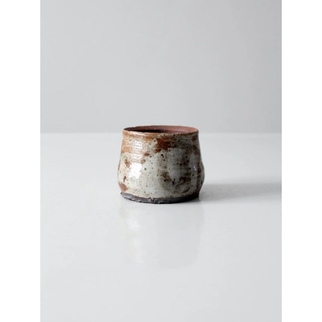 Striking vintage studio pottery vase, hand-crafted with a generously proportioned wide neck and finished in a warm,...