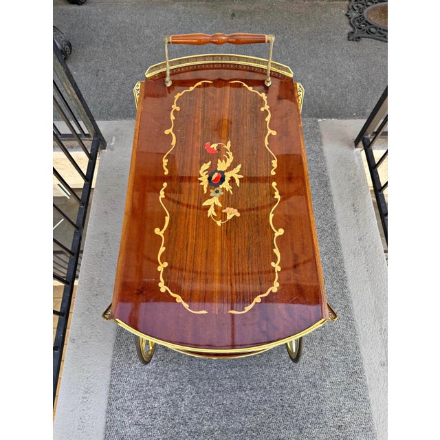 Elegant wood bar cart with pretty inlay design and shiny brass details. Two tiers for serving. Top tier expands. Wheels...