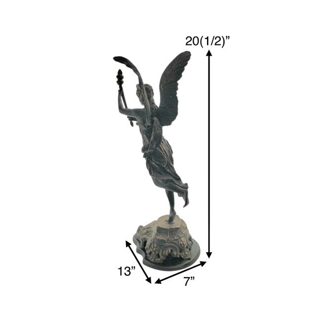 This vintage metal sculpture of a winged Greek goddess holding a torch, designed in an Art Deco and Art Nouveau style....